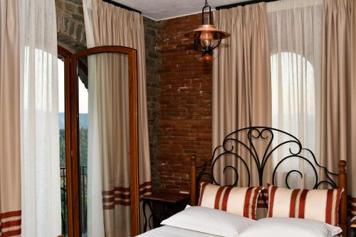 a bedroom with a bed and a brick wall at Hotel Restaurant Emblema in Petrelë