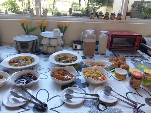 a table topped with bowls and plates of food at Niuniu & Meng Ka Homestay in Liugui