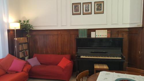 a living room with a piano and a red couch at Ostello Domus Civica in Venice