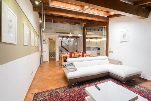 a living room with two white couches and a rug at Alkimia Smart Rooms in Ferrara