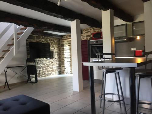 uma cozinha com uma mesa e uma lareira de pedra em Callac gîte P 8 em Plumelec