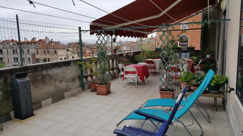a balcony with a table and chairs on a building at Ostello Domus Civica in Venice