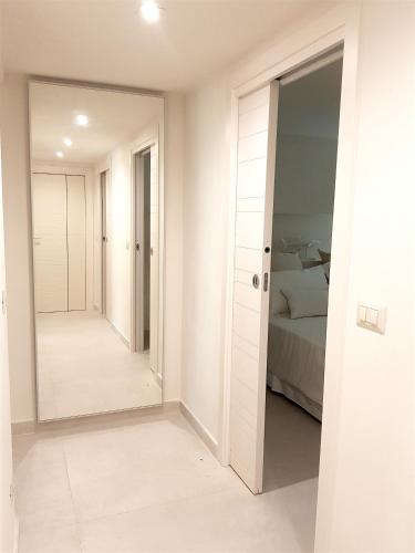 a white bedroom with a mirror and a bed at MINZONI94 - TwoBedroom+Garden in Lido di Camaiore
