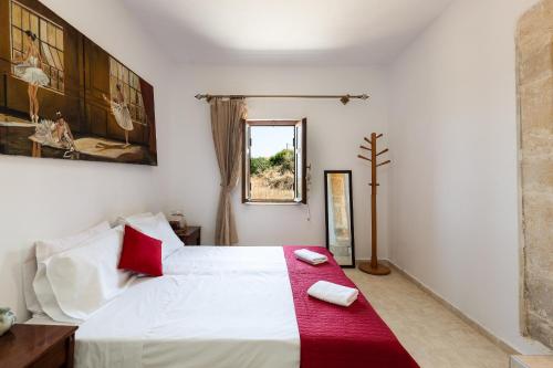 a bedroom with a large white bed with red pillows at Erato House in Koúfi