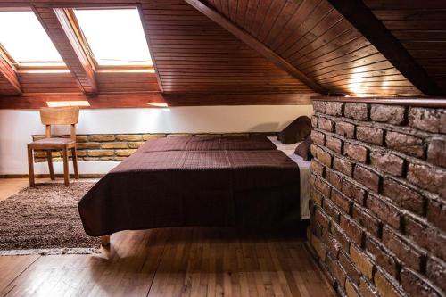 - une chambre avec un lit et un mur en briques dans l'établissement Miha Apartman, à Subotica