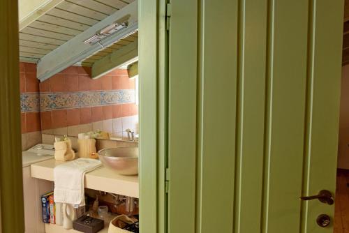 un bagno verde con lavandino e specchio di Mavres Luxury Loft ad Ágios Matthaíos