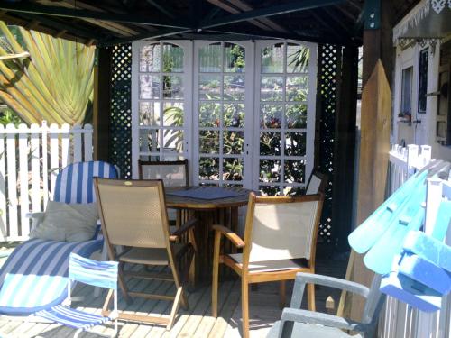 a porch with chairs and a table and a window at Chambres Dhotes Nicole Maillot in Sainte-Marie