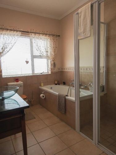 a bathroom with a bath tub and a shower at At 29 Columba in Groot Brak Rivier