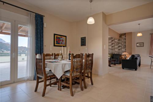 jadalnia ze stołem i krzesłami oraz salon w obiekcie Aliki Serenity Cottage w mieście Mixórrouma