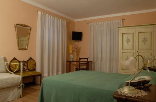 ein Schlafzimmer mit einem Bett, einem Sofa und einem Spiegel in der Unterkunft B&B Le Camelie in Domodossola