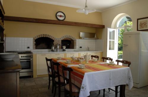 a kitchen with a table with chairs and a refrigerator at B&B Le Camelie in Domodossola