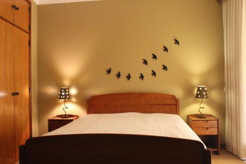 ein Schlafzimmer mit einem Bett mit Vögeln an der Wand in der Unterkunft River-side Villa in Vila Nova de Cerveira