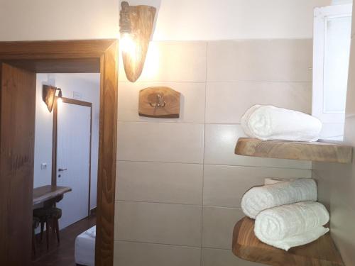 a bathroom with a pile of towels on a wall at Hotel Omer in Berat