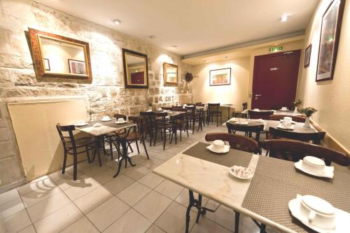 une salle à manger avec des tables et des chaises dans un restaurant dans l'établissement Hotel William's Opera, à Paris