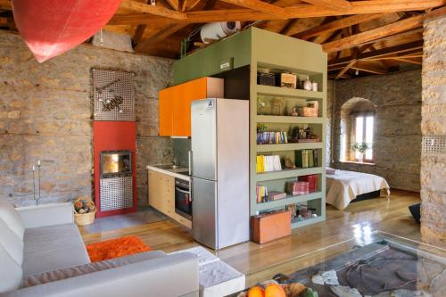 a kitchen with a refrigerator in the middle of a room at Cottage House in Traditional Greek Village in Kanália