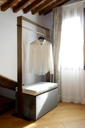 a white shirt on a hanger in a room with a window at Residence La Fenice in Venice