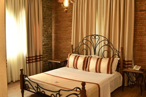 a bedroom with a bed and a window with curtains at Hotel Restaurant Emblema in Petrelë