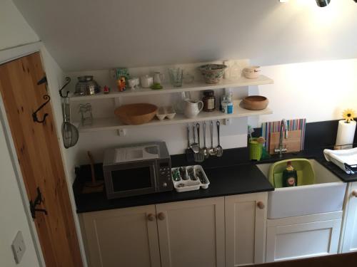 a kitchen with a counter top with a microwave at Little Woodacott in Barnstaple