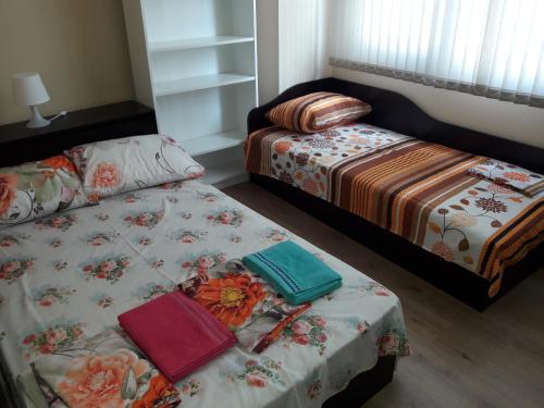 a bedroom with two beds and a table with books at Guest House Mania in Sofia