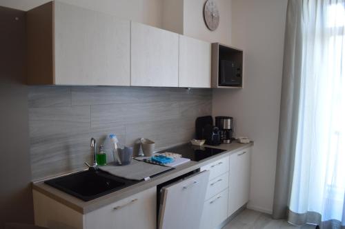 a kitchen with white cabinets and a sink and a window at Appartamento Campagnola 1 in Riva del Garda