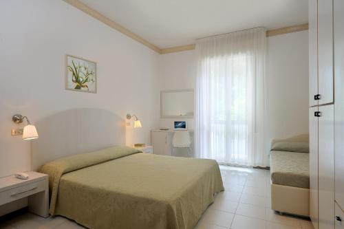 um quarto de hotel com uma cama e uma janela em Hotel Suisse em Milano Marittima