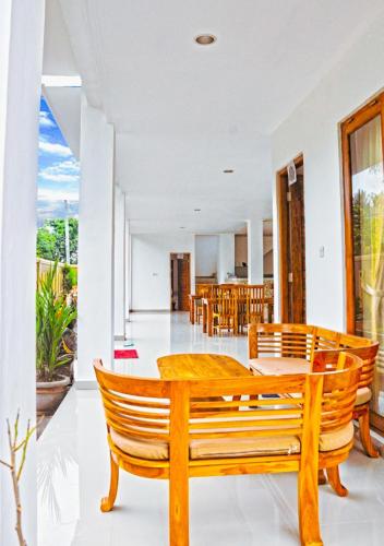 a dining room with a wooden table and chairs at Kailash Homestay in Padangbai