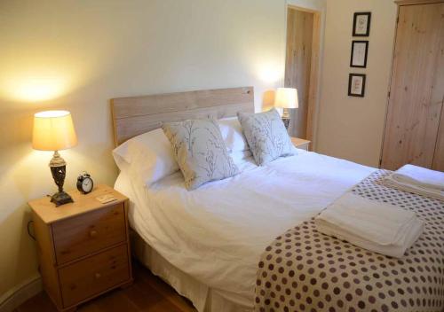 1 dormitorio con 1 cama blanca grande y 2 almohadas en Raleigh Barn, en West Putford