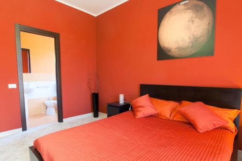 a bedroom with orange walls and a bed with orange pillows at Kosmos in Siracusa