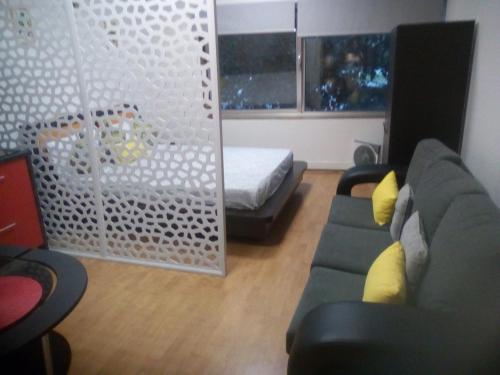 a living room with a couch and a bed at Metro-Apartment RNAL nº35375 AL-Chamada para a rede móvel nacional in Porto