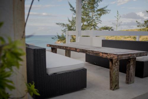 a table and chairs on a patio with the ocean at Greco Hotel in Búzios