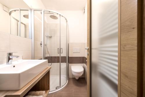een badkamer met een wastafel, een douche en een toilet bij Niederhof life in Lana