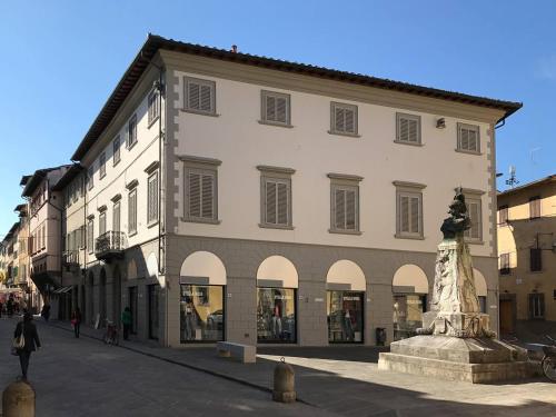un grand bâtiment avec une statue en face dans l'établissement Palazzo Vasarri - Luxury design suites, à Montevarchi