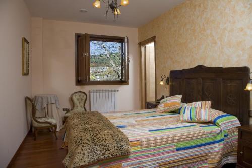 ein Schlafzimmer mit einem Bett mit einer Gepard-Decke in der Unterkunft Casa da Capilla in Gres