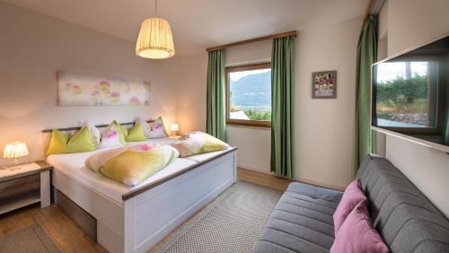 1 dormitorio con cama, ventana y sofá en Niederhof life en Lana