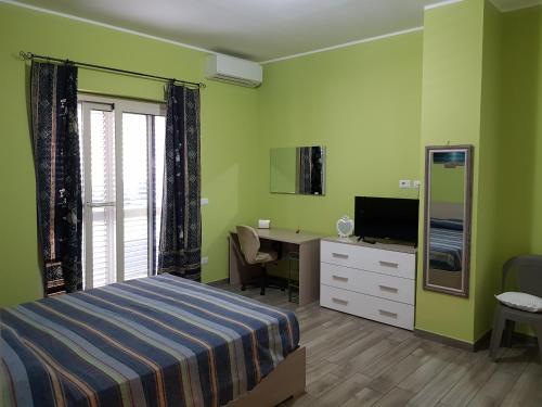 a bedroom with a bed and a desk and a television at Sea and Sun House in Santa Teresa di Riva