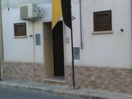 una puerta abierta de un edificio blanco con bandera amarilla en Elisea House, en Oria