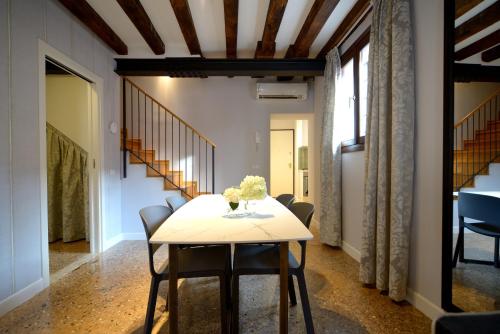 a dining room with a table and chairs and stairs at Residence La Fenice in Venice