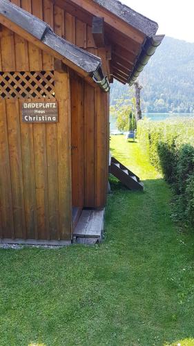 a wooden building with a sign on the side of it at Haus Christina in Weissensee