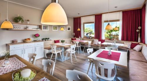 a restaurant with tables and chairs in a room at Niederhof life in Lana