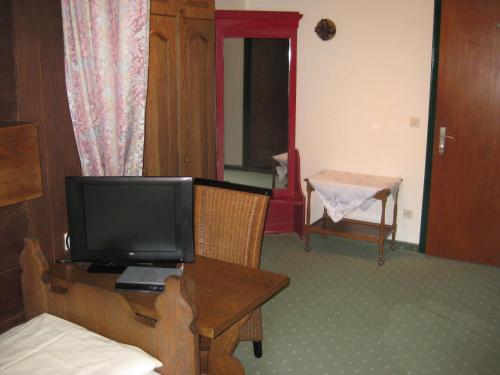 a room with a television and a table with a bed at Panoramahotel Karwendelhof in Wallgau