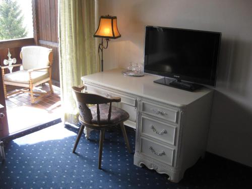 a room with a dresser with a television on it at Panoramahotel Karwendelhof in Wallgau