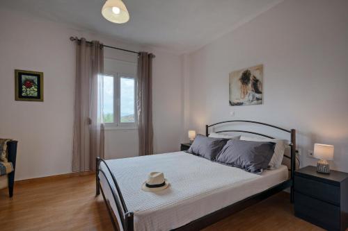 sypialnia z łóżkiem z kapeluszem w obiekcie Aliki Serenity Cottage w mieście Mixórrouma