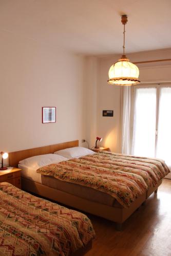 a bedroom with two beds and a chandelier at Garni Hirsch in Canazei