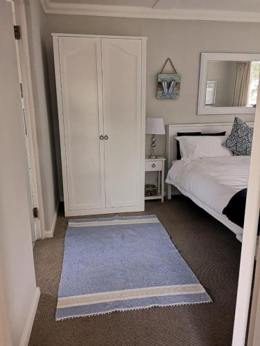 a bedroom with a white cabinet and a bed at On Cloud 9 in Hermanus