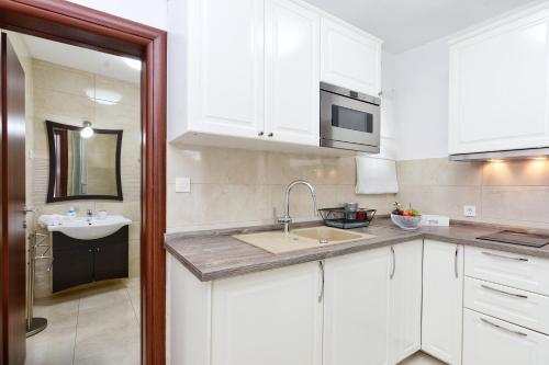 a kitchen with white cabinets and a sink at Apartments Maritea in Vodice