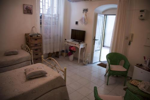 una camera con 2 letti, una scrivania e una TV di B&B Paradiso San Vincenzo a Molfetta