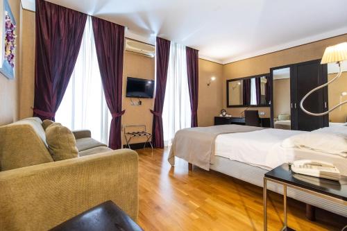 ナポリにあるMH デザイン ホテルのベッドとソファ付きのホテルルーム