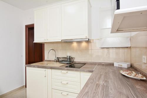 a kitchen with white cabinets and a sink at Apartments Maritea in Vodice