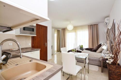 Apartments Maritea في فوديس: مطبخ وغرفة معيشة مع أريكة