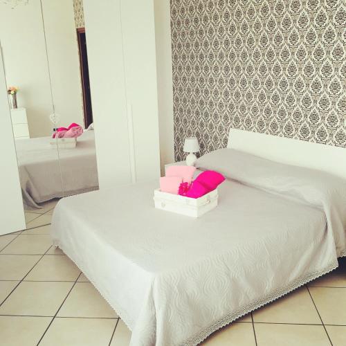 ein Schlafzimmer mit einem weißen Bett mit rosa Laken und einem Spiegel in der Unterkunft Lisa’s House in Neapel